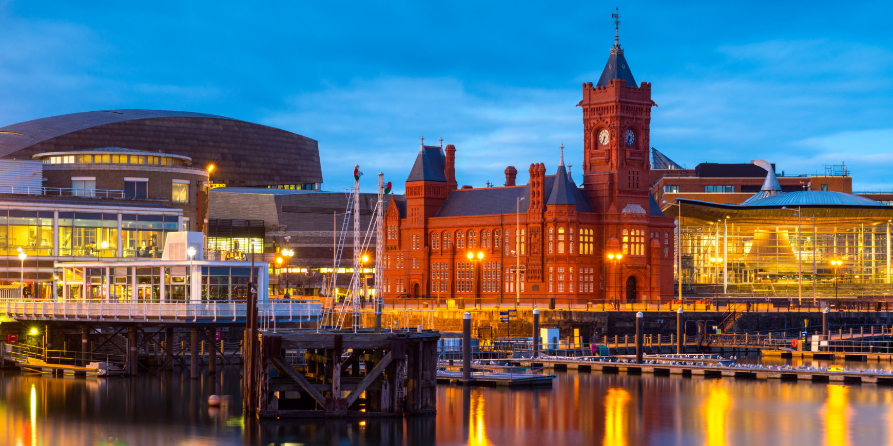 A view of Cardiff Bay at night, with the Pierhead Building and other buildings illuminated.